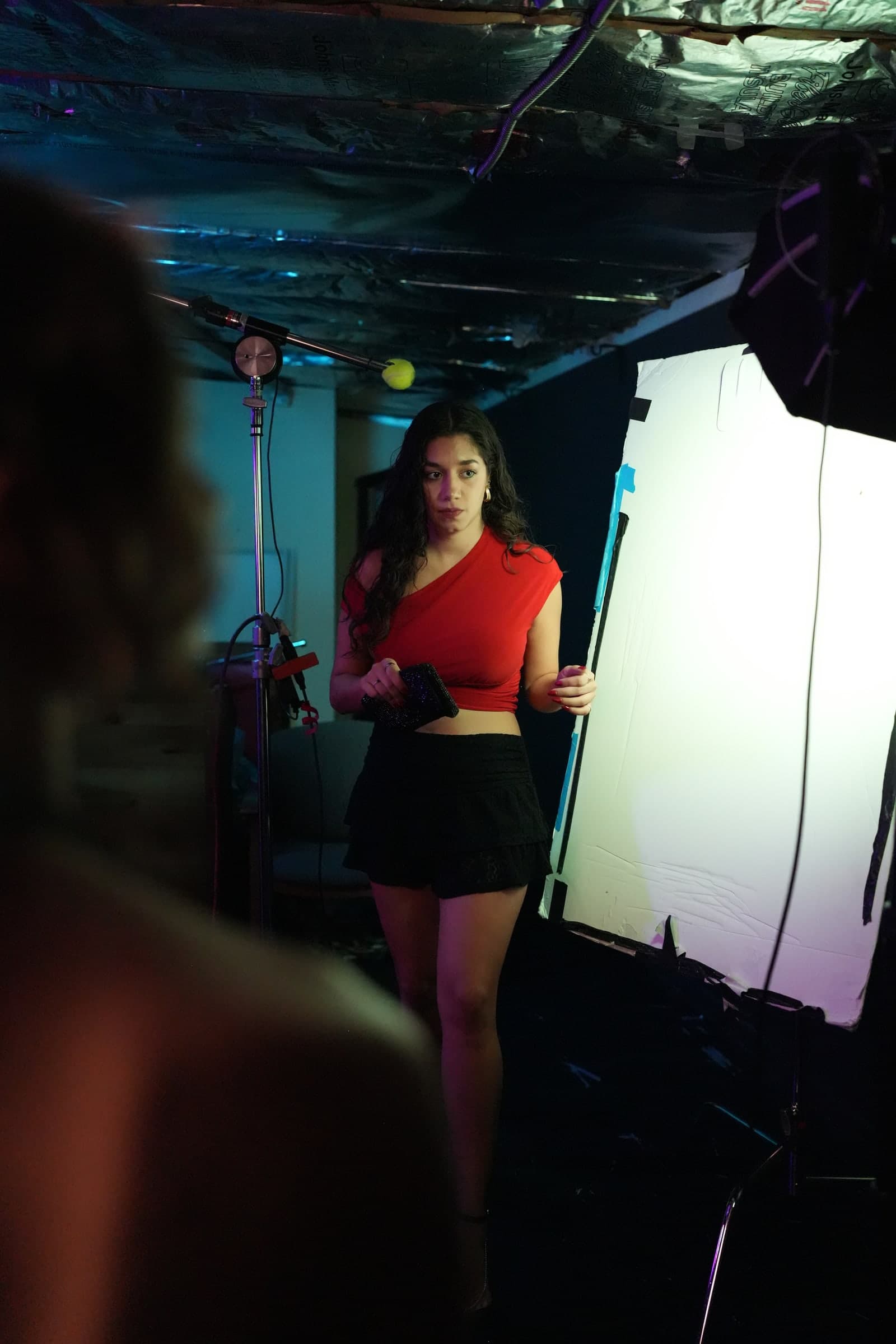 Emily Loaiza on set beside a bounce board and boom microphone