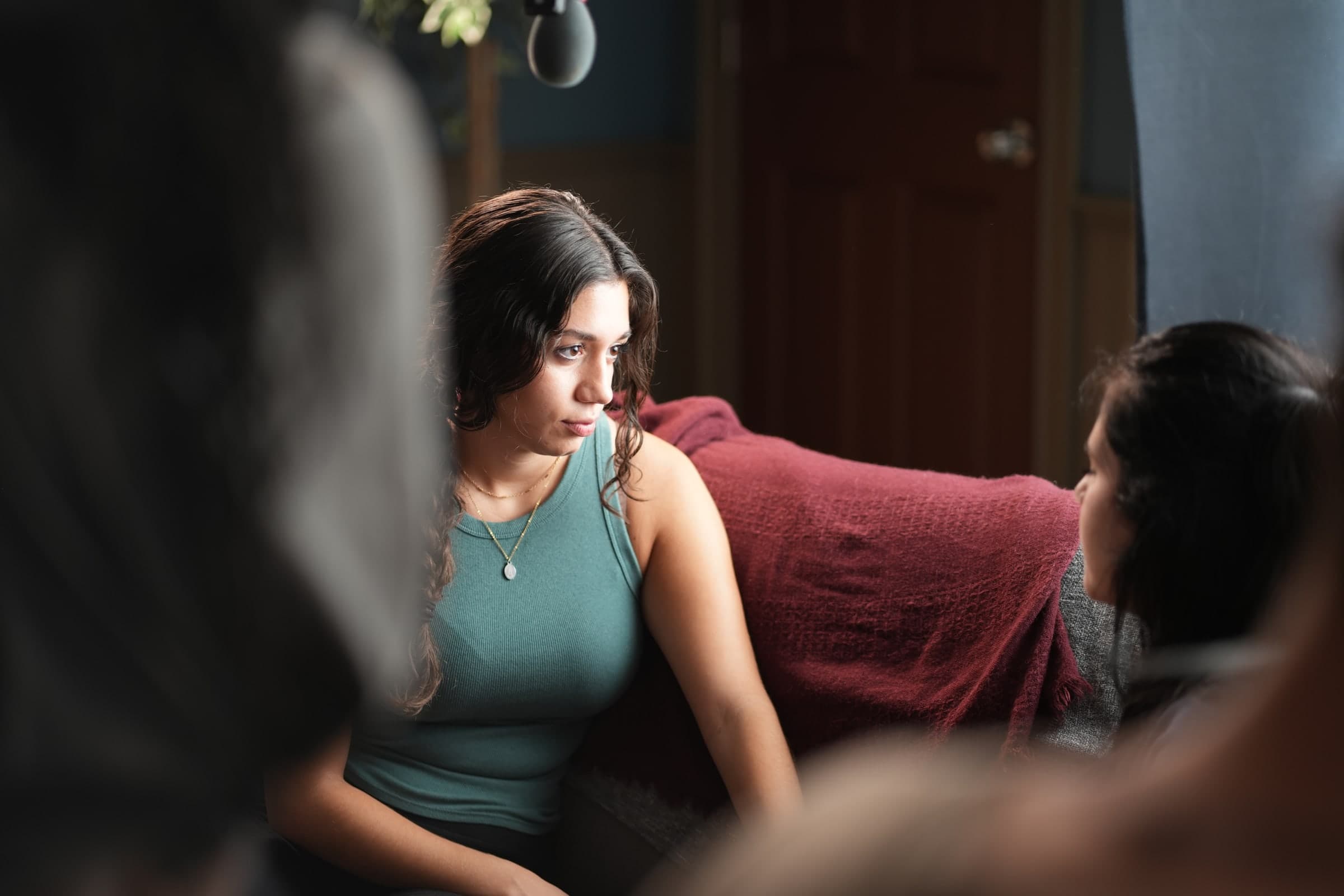Emily Loaiza on a couch, listening intently during a take