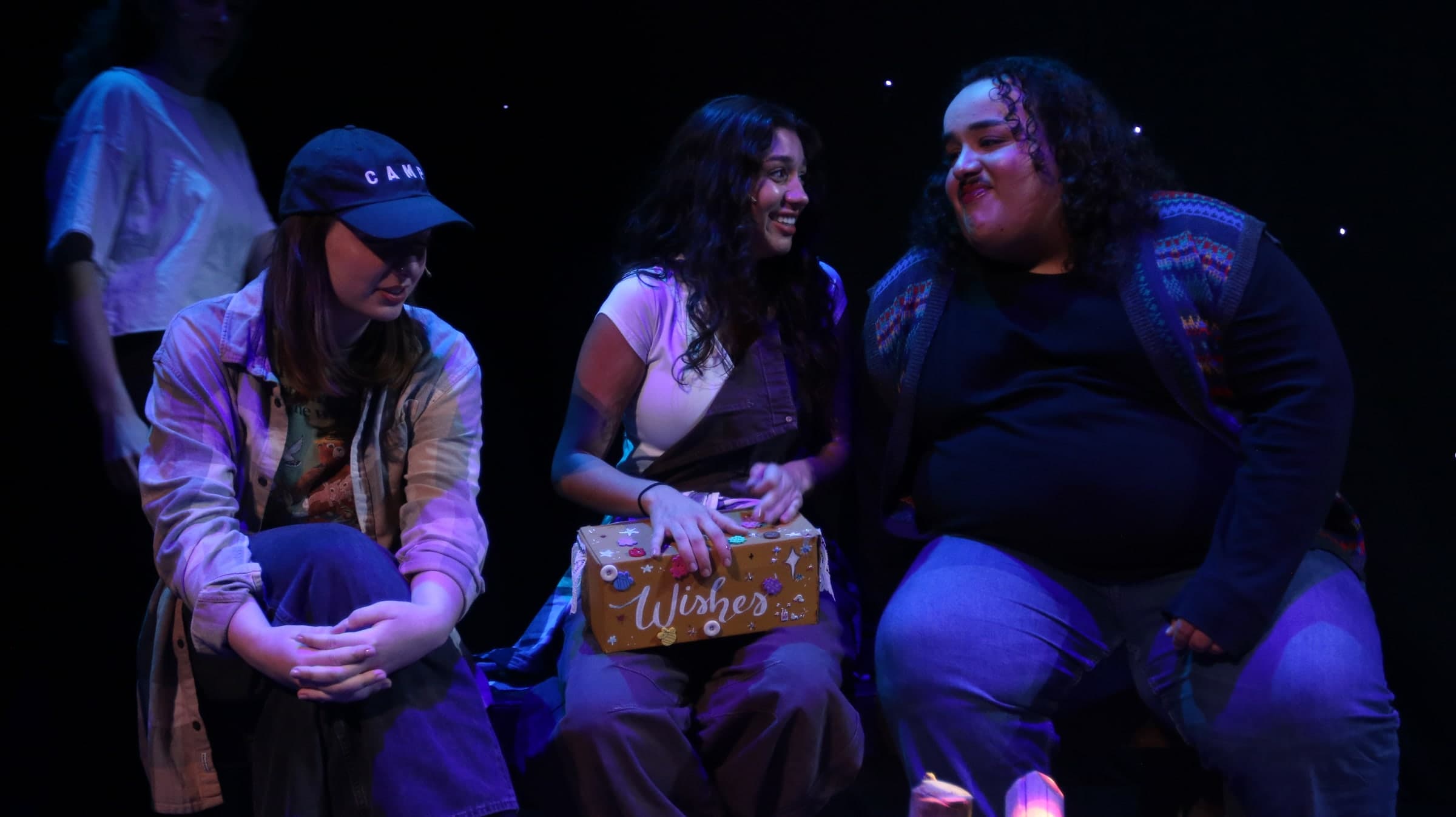 Emily Loaiza laughing during a campfire scene on stage