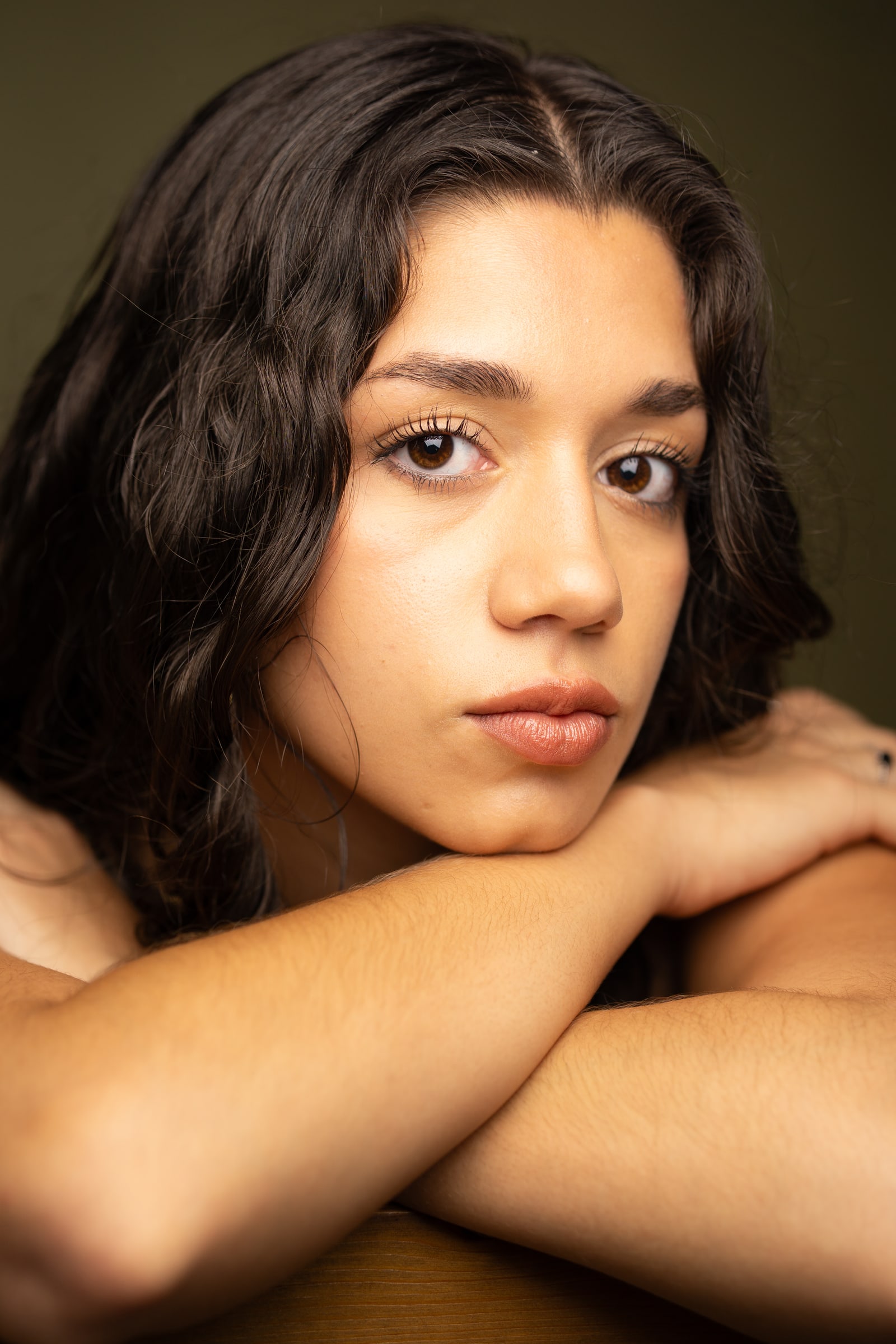 Emily Loaiza resting her chin on her crossed arms, looking into the camera